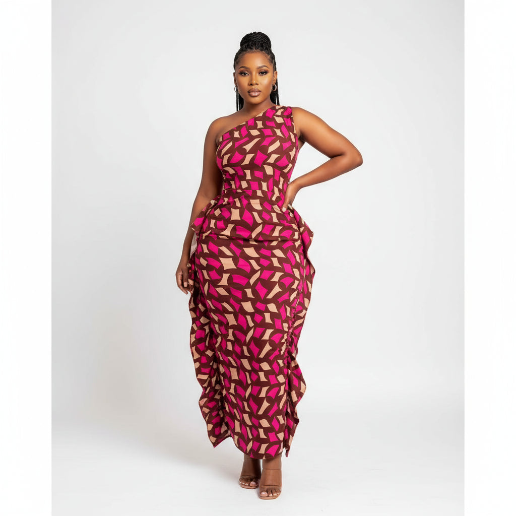 A person wearing a one arm printed dress with a geometric pattern in colors including black, red, and pink.