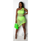 Woman wearing a neon green fishnet dress holding a matching handbag against a white background.