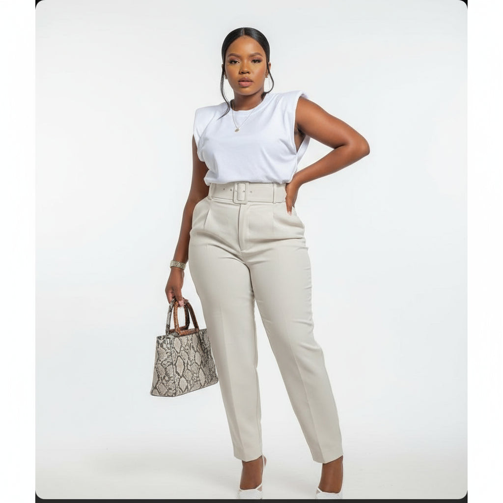 A person wearing high waisted skinny formal pants with a belt, in a light color, posing outdoors.