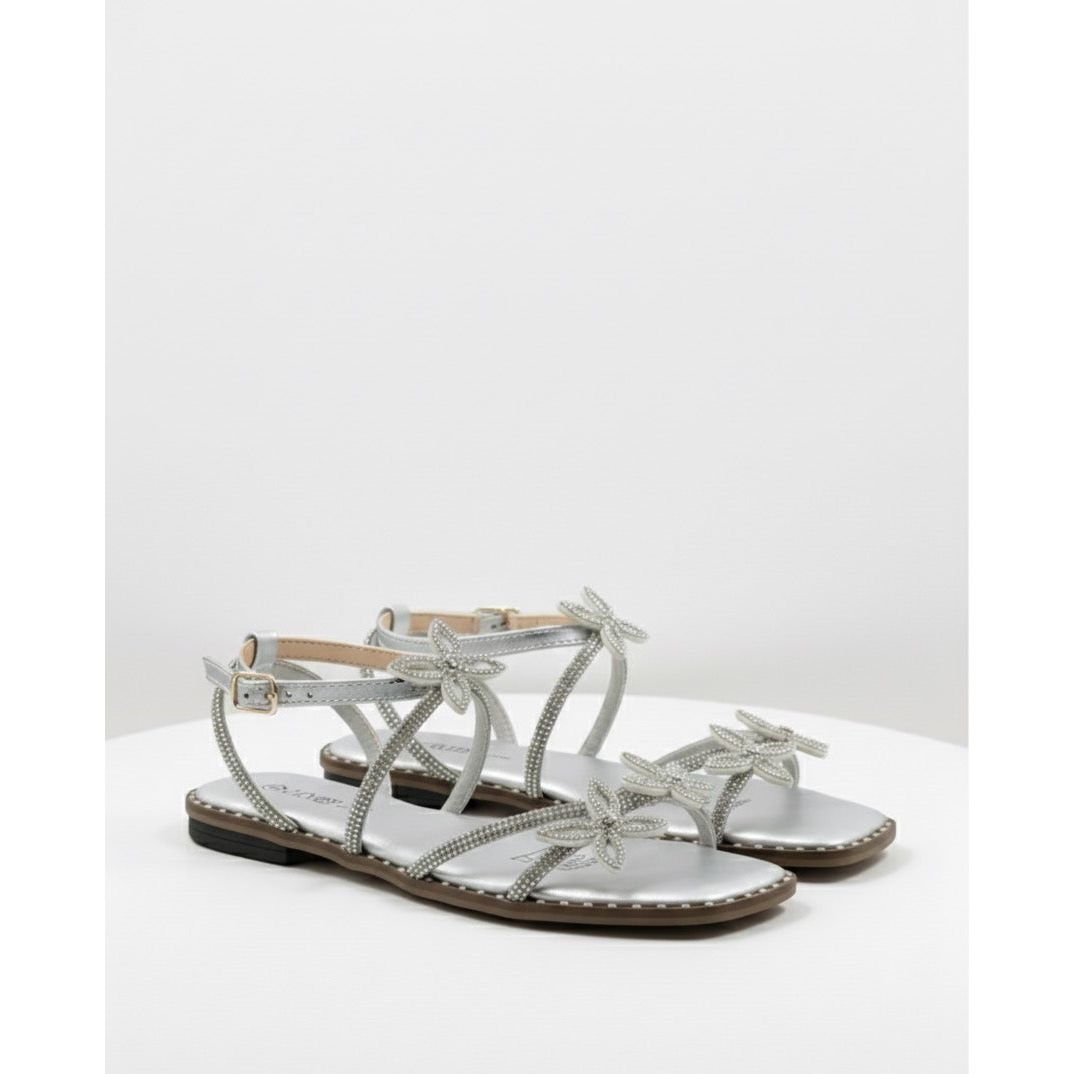 Silver sandals with bow details on a white surface