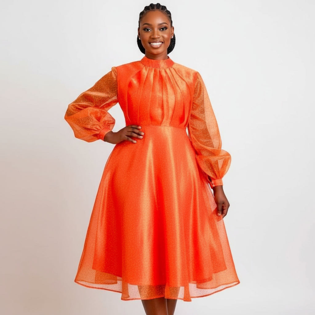A woman wearing an orange midi dress with pleated and fluffy sleeves.