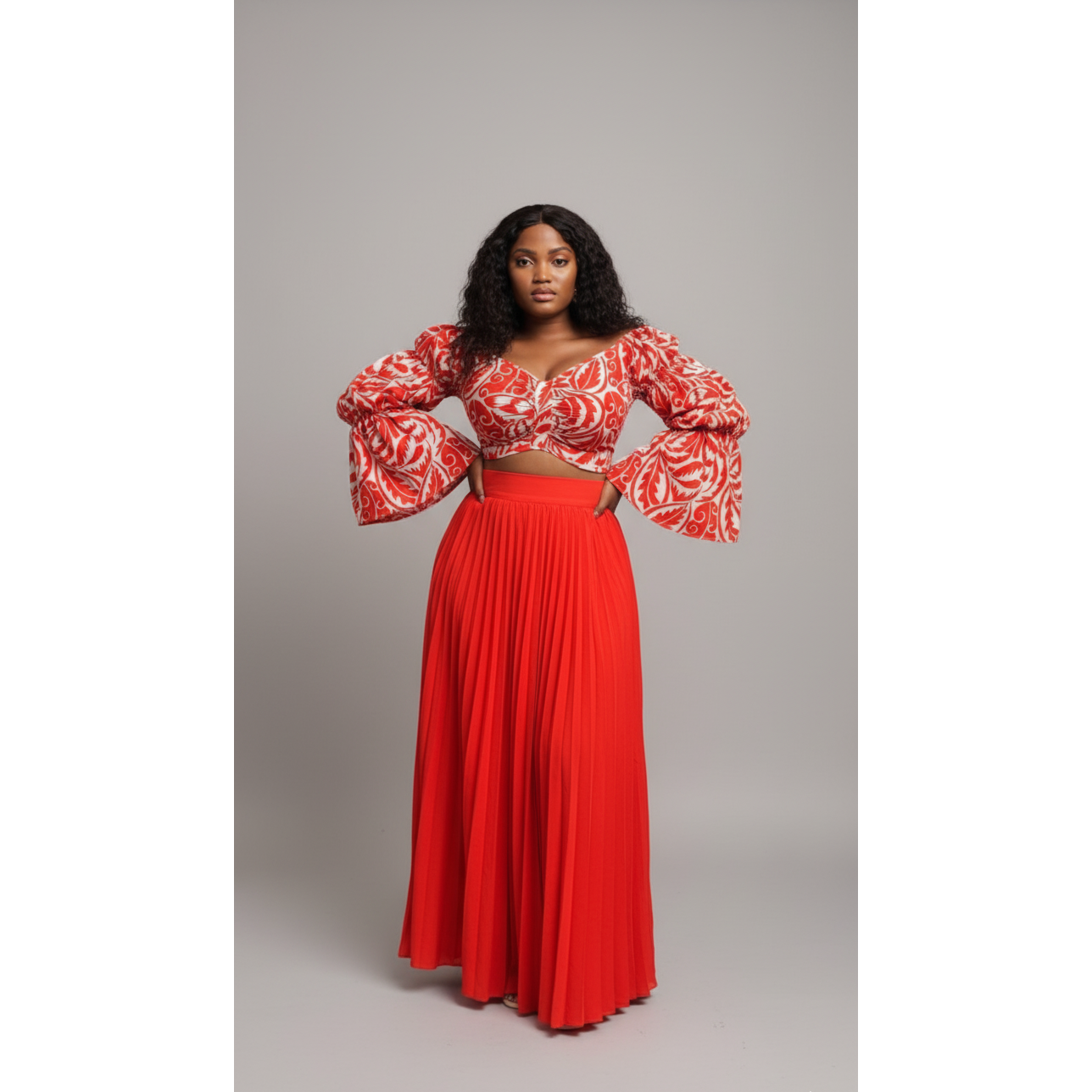 Woman wearing a red and white patterned top and red skirt on a gray background