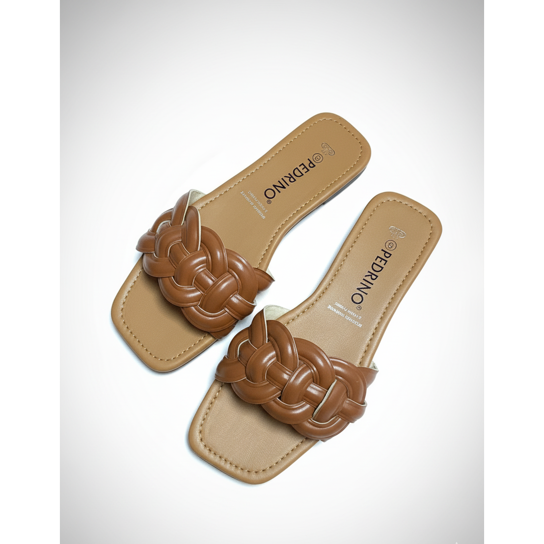 Pair of tan sandals with braided brown straps on a light gray background