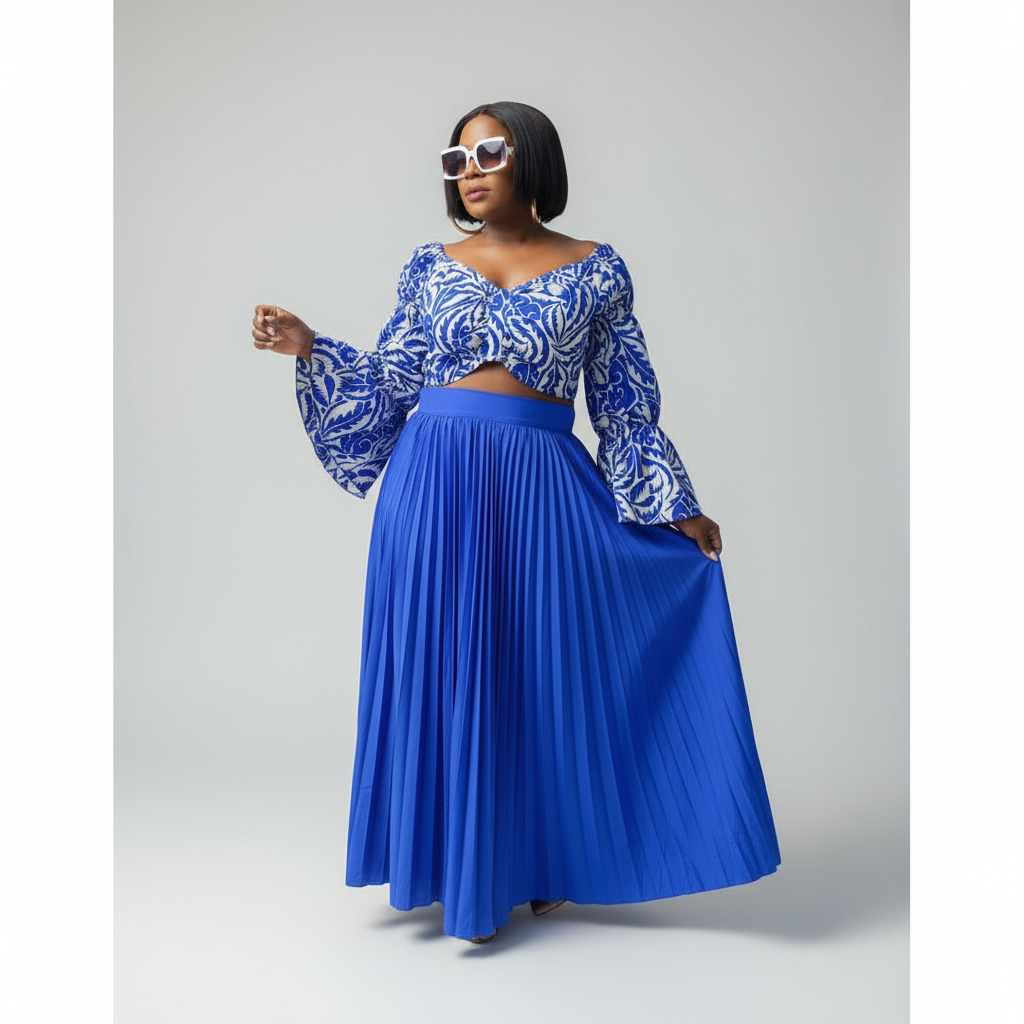 Woman wearing a blue and white patterned top with a long blue skirt on a gray background