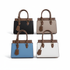 Four handbags in black, beige, blue, and white with brown handles and accents on a white background.