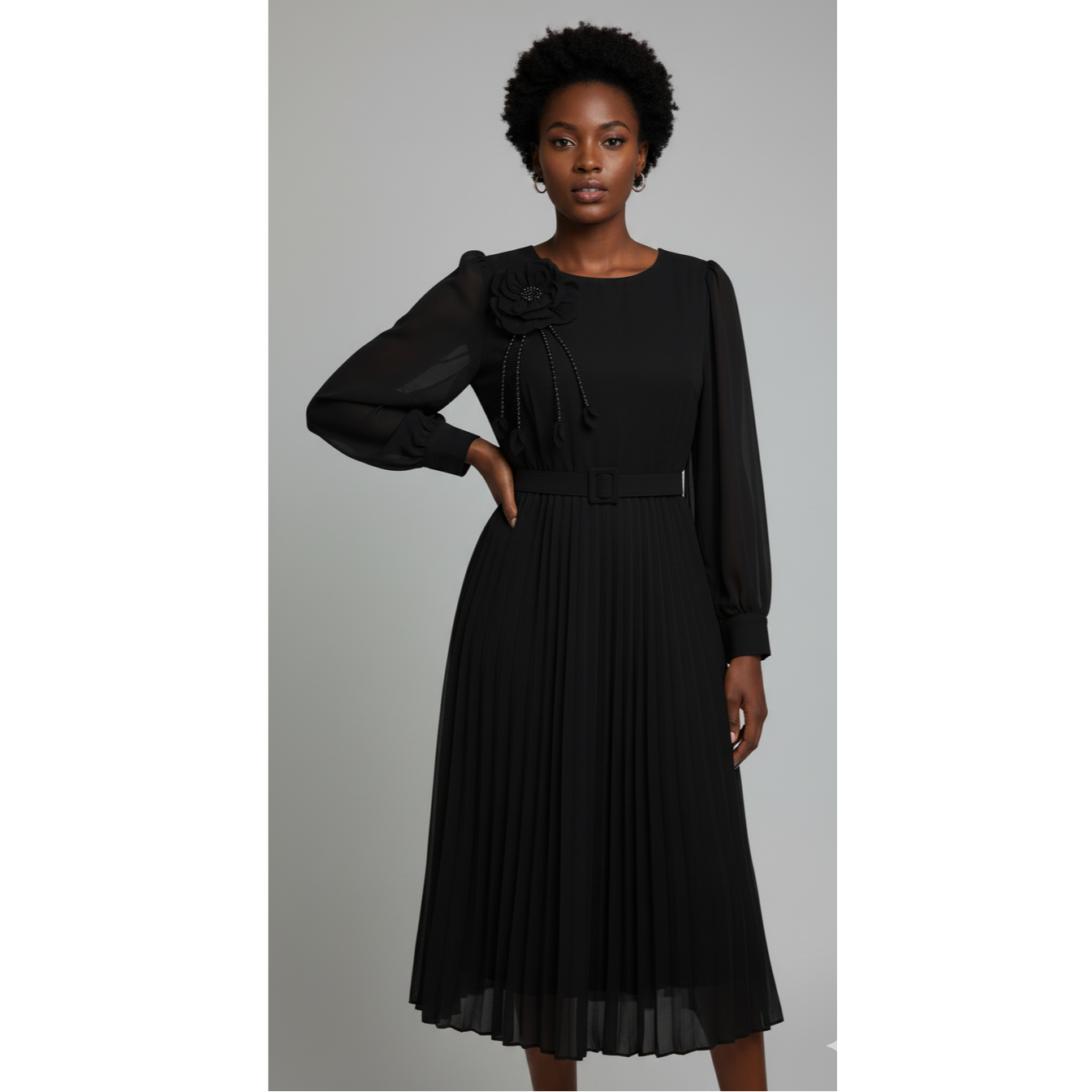 Woman wearing a black dress with sheer sleeves on a gray background