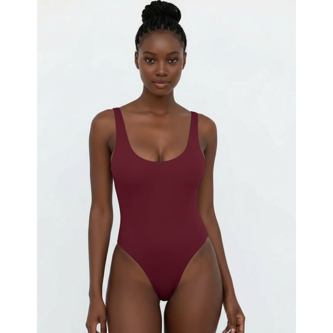 Woman wearing a white one-piece swimsuit against a plain background