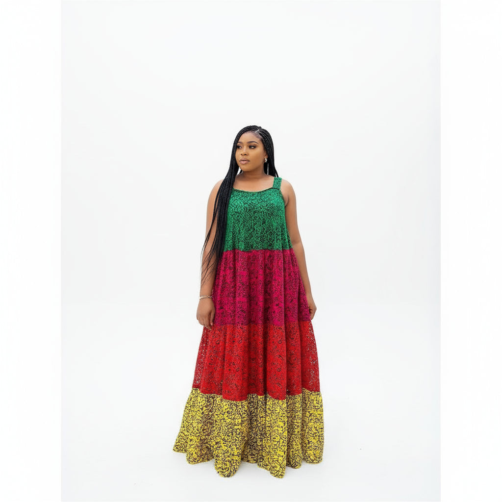 A woman wearing an off-shoulder, pleated maxi dress with a vibrant African print. The dress features red, green, and yellow colors with a floral pattern.