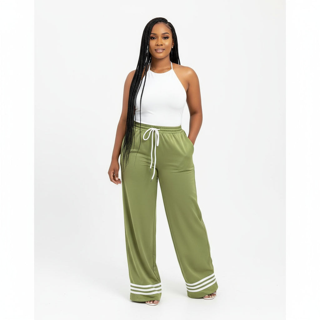 A person wearing green solid color drawstring tie pants with a white top, featuring a high waist and pockets.