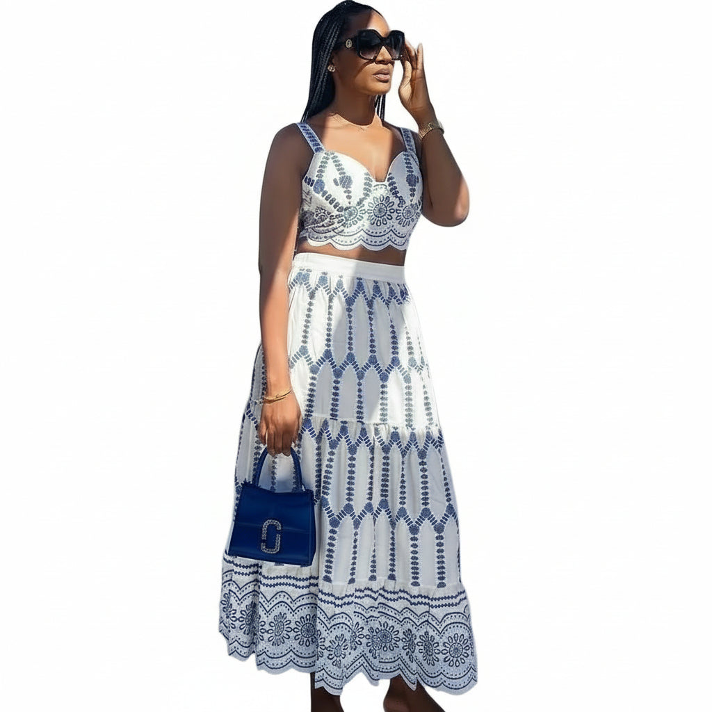 Woman wearing a white and blue lace dress with a blue handbag on a gray background