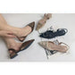 Brown flat shoes with decorative buckle near a poolside setting.