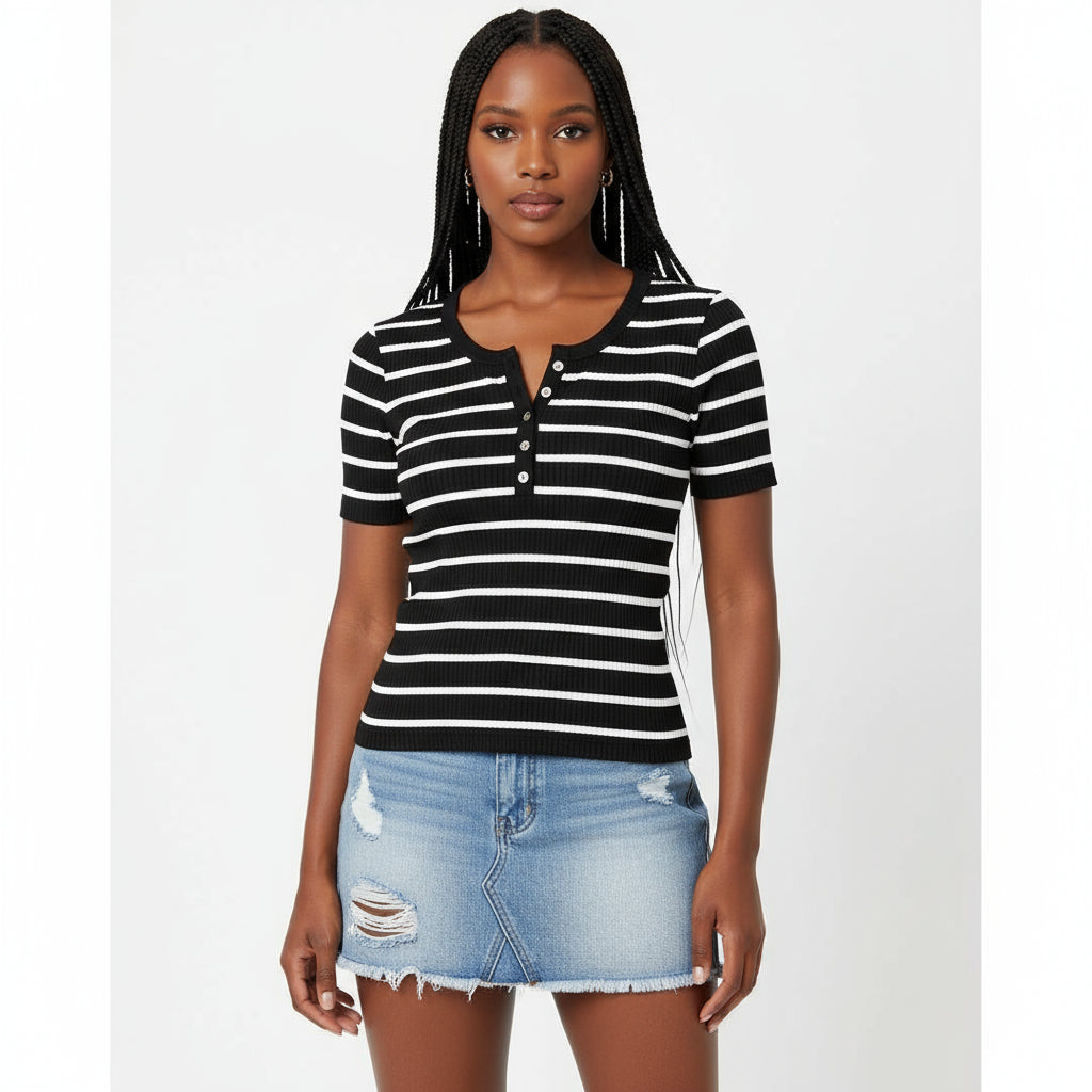 Woman wearing a black and white striped shirt and denim skirt indoors.