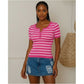 Woman wearing a pink and white striped shirt and denim shorts indoors.