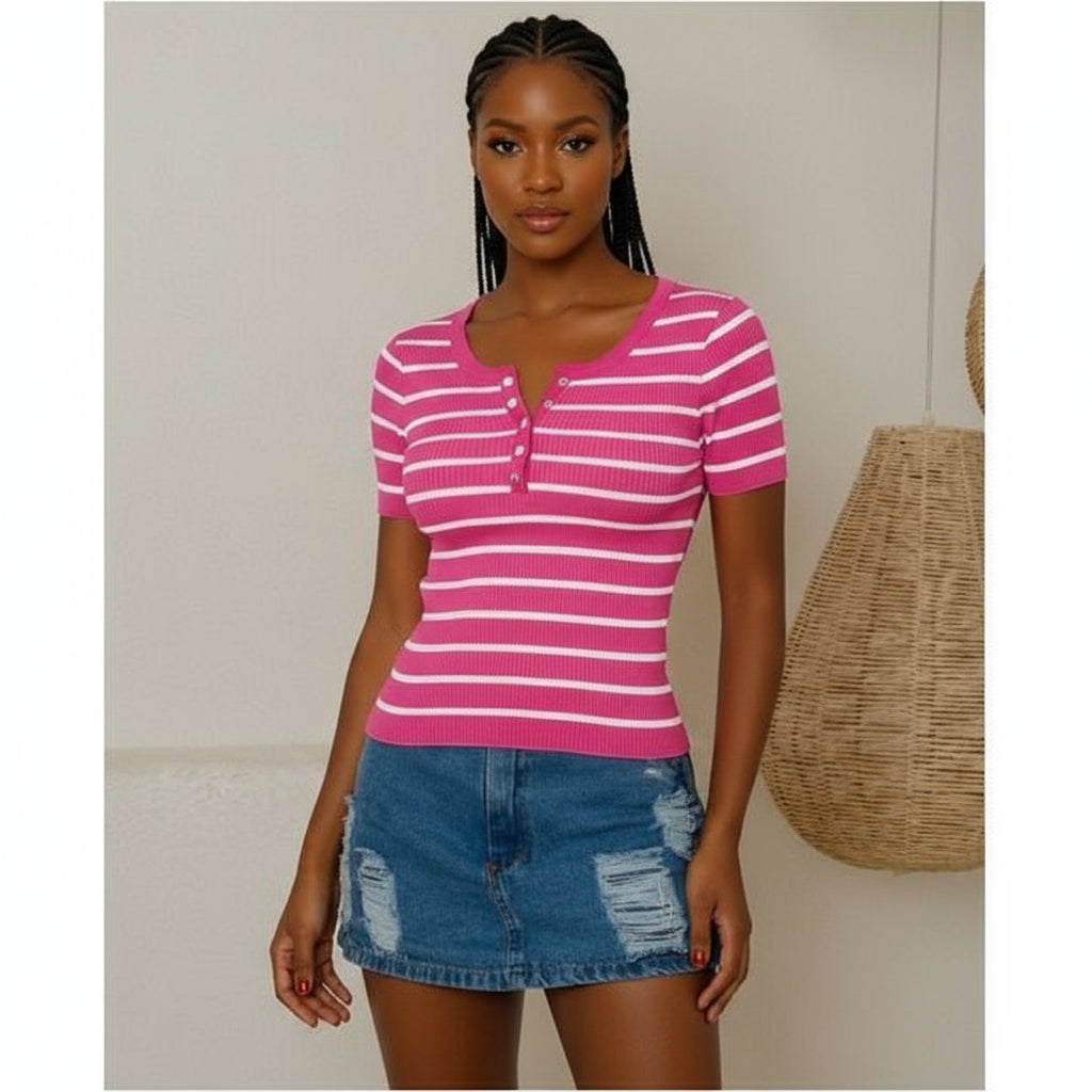 Woman wearing a pink and white striped shirt and denim shorts indoors.