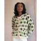 Woman wearing a green and brown argyle patterned cardigan against a plain background