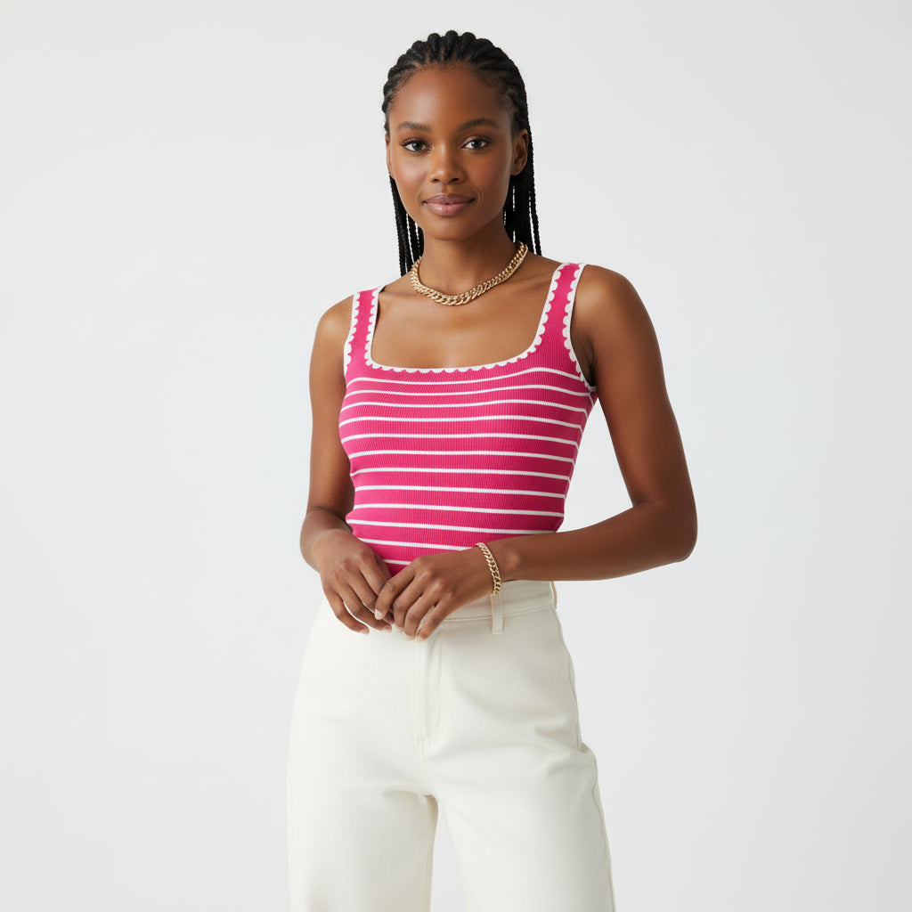 Person wearing a pink and white striped tank top with gold chain necklace against a neutral background