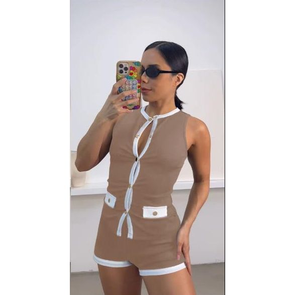 Woman taking a mirror selfie wearing a brown and white outfit.