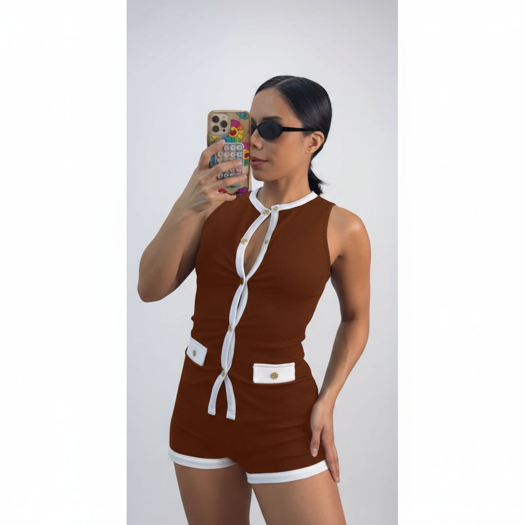 Woman wearing a brown and white outfit with sunglasses, taking a mirror selfie.