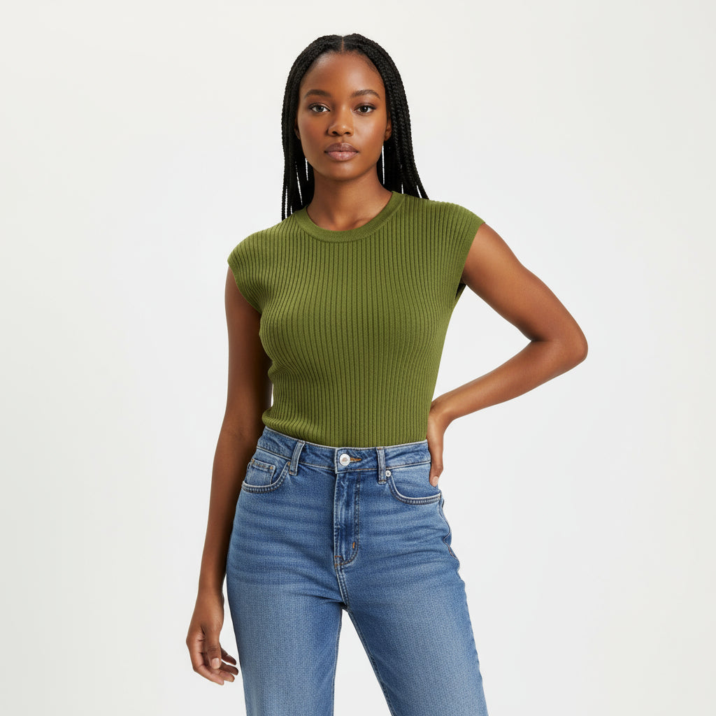 Person wearing a green ribbed crop top and blue jeans on a white background