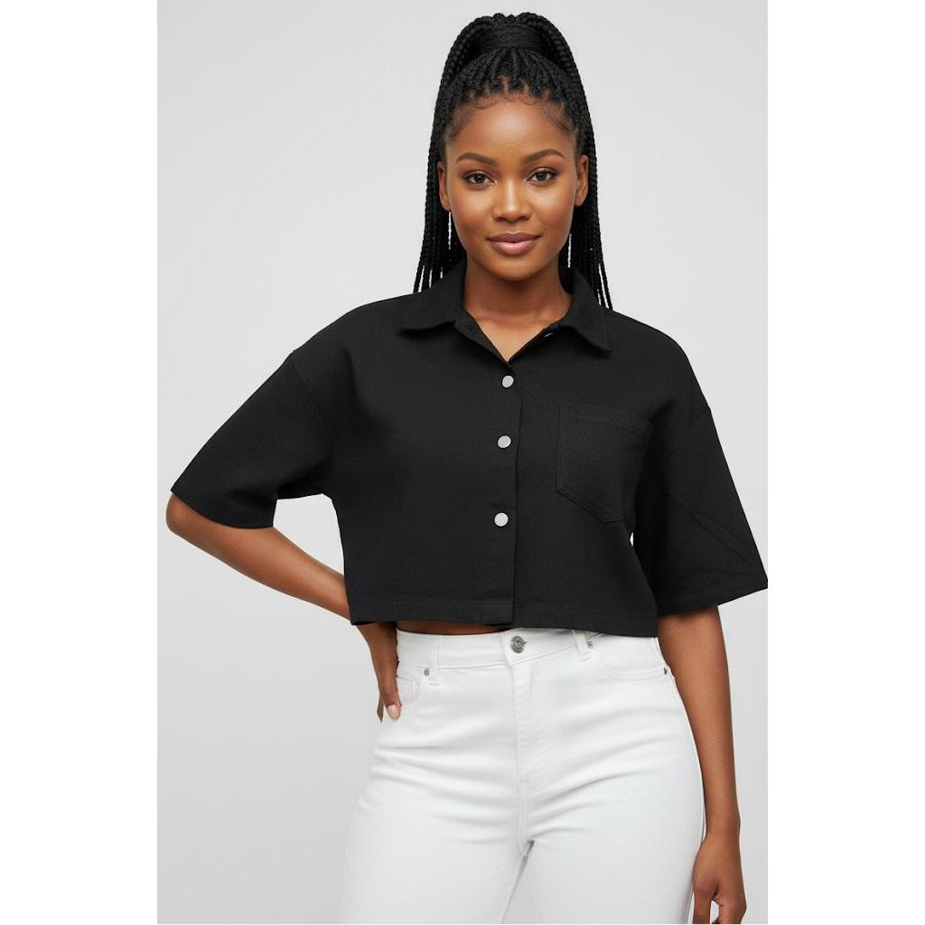 Woman wearing a black cropped shirt and white pants on a gray background