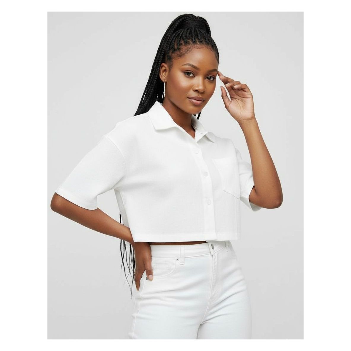 Woman wearing a white shirt and white pants against a light gray background