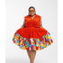 Woman wearing a bright orange dress with a colorful floral skirt on a white background
