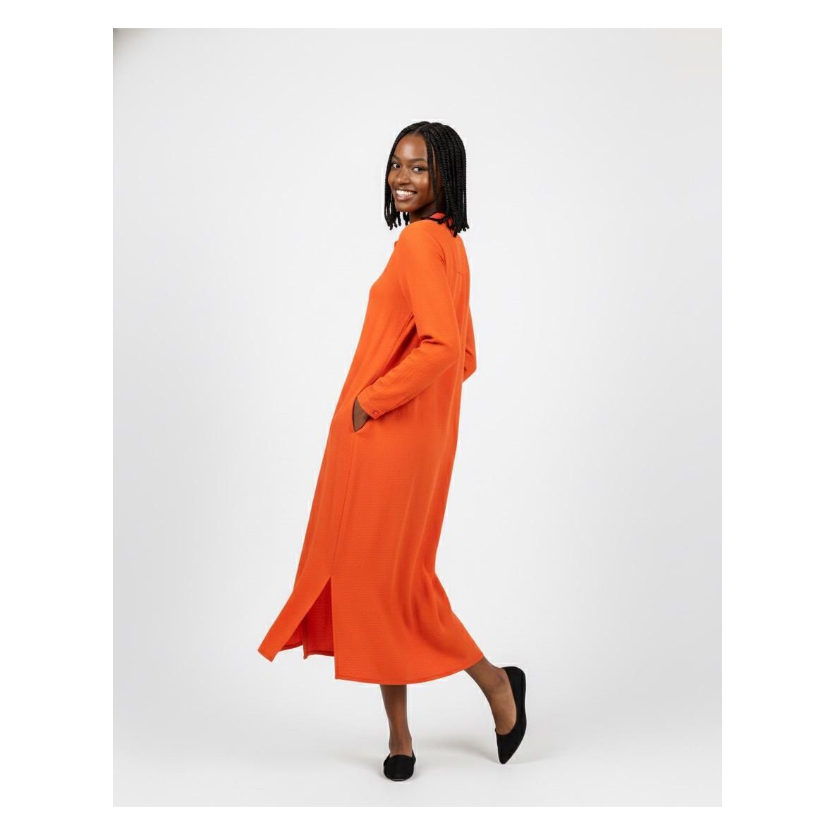 Woman wearing an orange dress on a white background