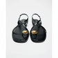 Black sandals with gold accents on a white background