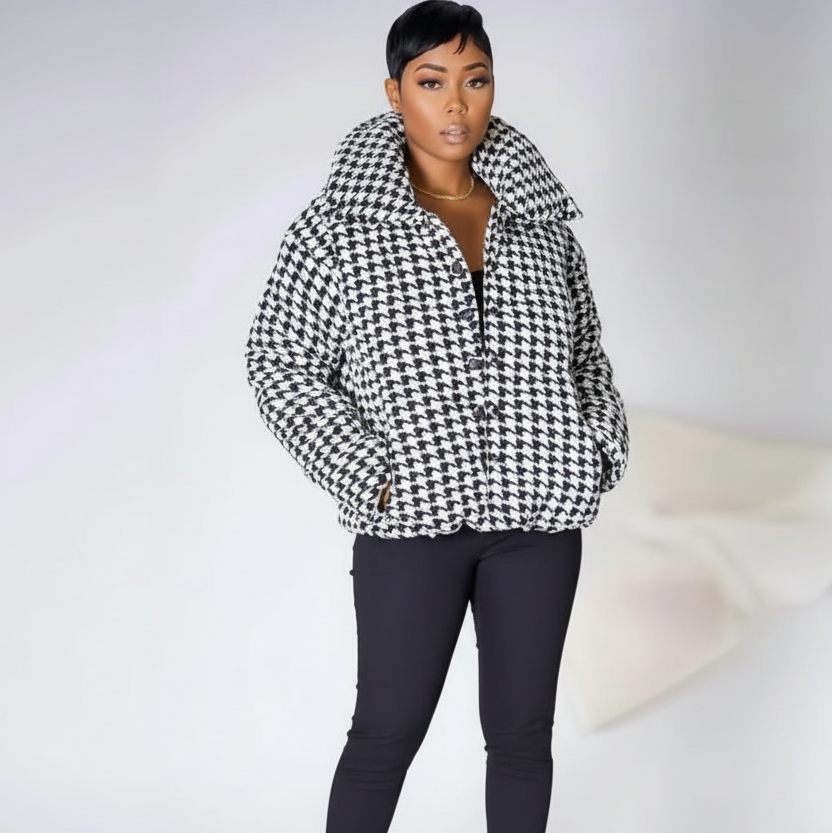Person wearing a houndstooth pattern jacket on a white background
