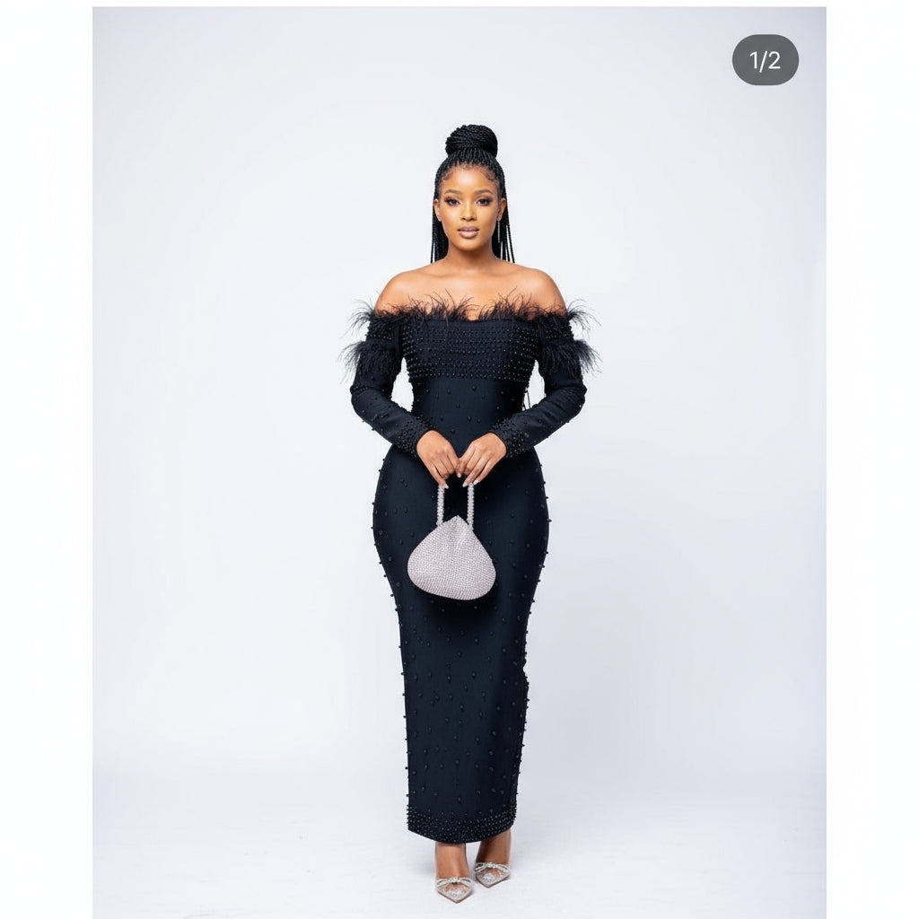 A woman wearing an off-shoulder black dress with bead details, standing in a mall.