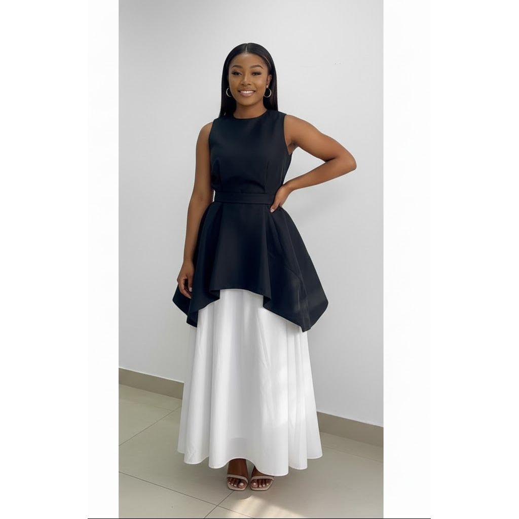 Woman wearing a black top and white skirt against a plain background