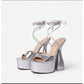 A pair of silver, thick heel platform ankle strap shoes with open toes and tied ankle straps.