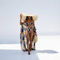 A model wearing a multicolor geometric patterned swimsuit with a long kimono cover-up and a wide-brimmed hat.